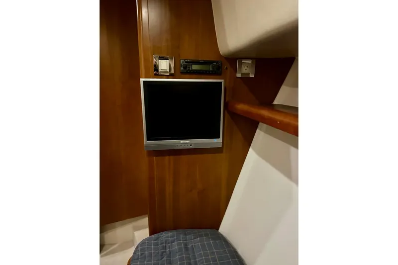  Yacht Photos Pics 2005 Bertram 390 Convertible interior with wall-mounted TV and wooden paneling.
