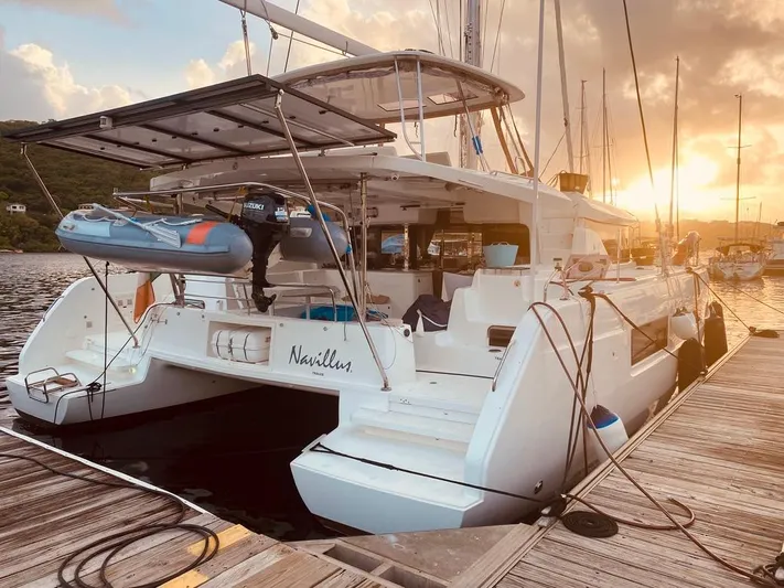 Navillus-3 Yacht Photos Pics 2022 Lagoon 46 catamaran docked at sunset with dinghy on deck.