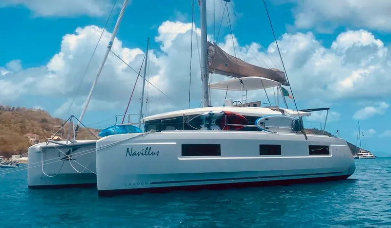 Navillus-3 Yacht Photos Pics 2022 Lagoon 46 catamaran sailing on clear blue waters under a sunny sky.