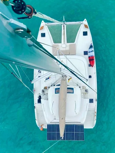 Navillus-3 Yacht Photos Pics Aerial view of 2022 Lagoon 46 catamaran sailing on turquoise water.