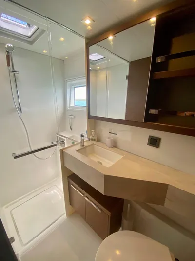 Navillus-3 Yacht Photos Pics Modern bathroom in 2022 Lagoon 46 yacht with shower, sink, and mirror.