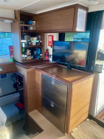 Navillus-3 Yacht Photos Pics Modern kitchen area in 2022 Lagoon 46 yacht with wooden cabinetry and appliances.