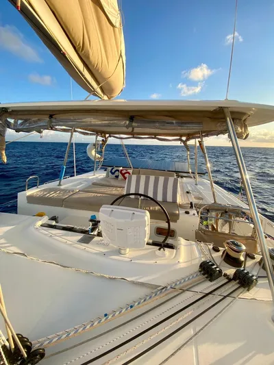 Navillus-3 Yacht Photos Pics 2022 Lagoon 46 catamaran sailing on open sea under clear blue sky.