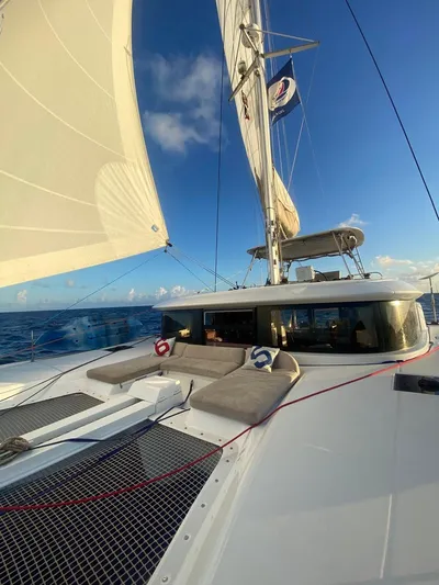 Navillus-3 Yacht Photos Pics 2022 Lagoon 46 sailing catamaran on open sea under clear blue sky.