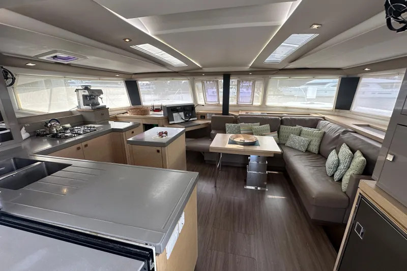 Grand Crew Yacht Photos Pics Luxurious interior of 2019 Fountaine Pajot 47 catamaran with modern kitchen and cozy seating area.