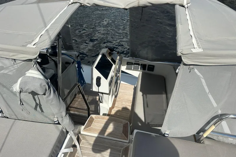 Grand Crew Yacht Photos Pics 2019 Fountaine Pajot 47 yacht cockpit with canopy and seating, overlooking water.