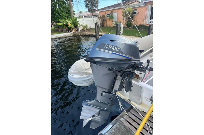 Grand Crew Yacht Photos Pics Yamaha outboard motor on a 2019 Fountaine Pajot 47 catamaran, docked by a waterfront home.