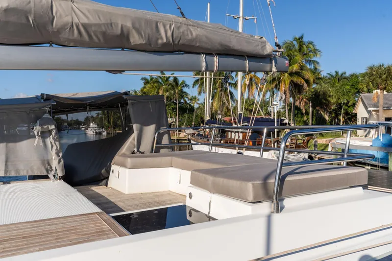 Grand Crew Yacht Photos Pics 2019 Fountaine Pajot 47 catamaran deck with sun loungers and tropical backdrop.