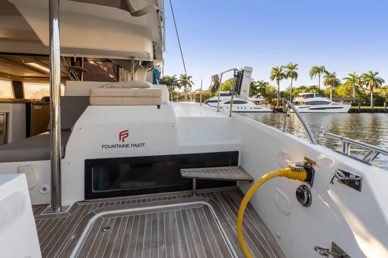 Grand Crew Yacht Photos Pics 2019 Fountaine Pajot 47 yacht deck with marina view and palm trees.