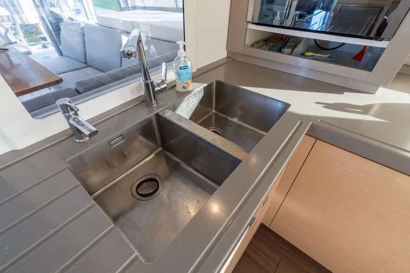 Grand Crew Yacht Photos Pics Modern kitchen sink area on 2019 Fountaine Pajot 47 yacht, featuring dual stainless steel basins.