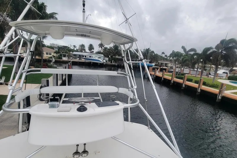 Miss Jayla Yacht Photos Pics 2004 Cabo 40 Express boat docked in a scenic marina with palm trees.