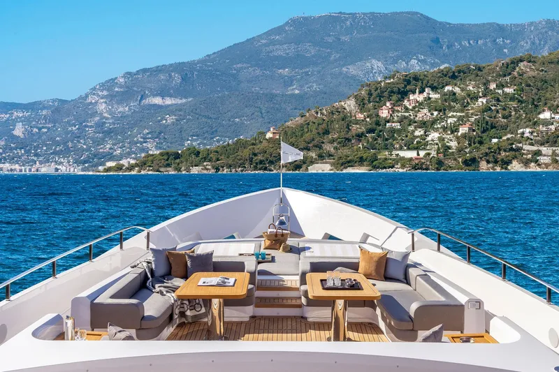  Yacht Photos Pics Luxurious 2022 Custom Line 140' yacht with elegant deck seating, scenic coastal backdrop.