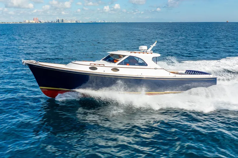 Volatility Yacht Photos Pics 2003 San Juan SJ 38 yacht cruising on open water, city skyline in background.