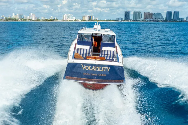 Volatility Yacht Photos Pics San Juan SJ 38 boat cruising on blue ocean near city skyline, 2003 model.