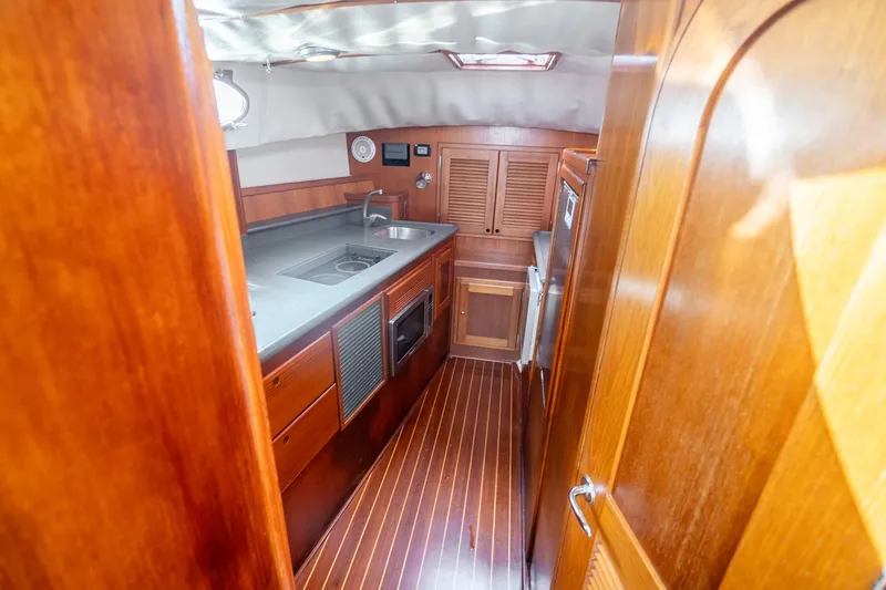 Volatility Yacht Photos Pics 2003 San Juan SJ 38 yacht interior with wooden cabinetry and modern kitchen amenities.