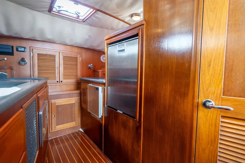 Volatility Yacht Photos Pics Wooden interior of 2003 San Juan SJ 38 yacht kitchen with stainless steel appliances.