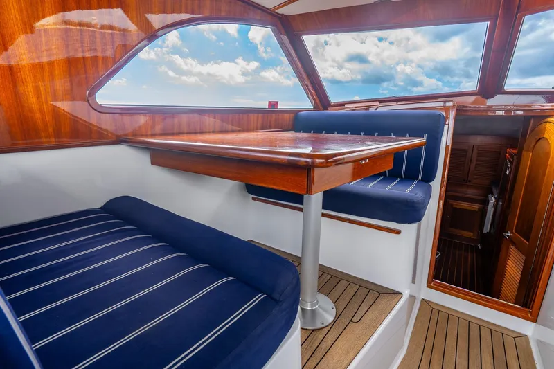 Volatility Yacht Photos Pics Luxurious interior of 2003 San Juan SJ 38 yacht with wooden table and blue seating.