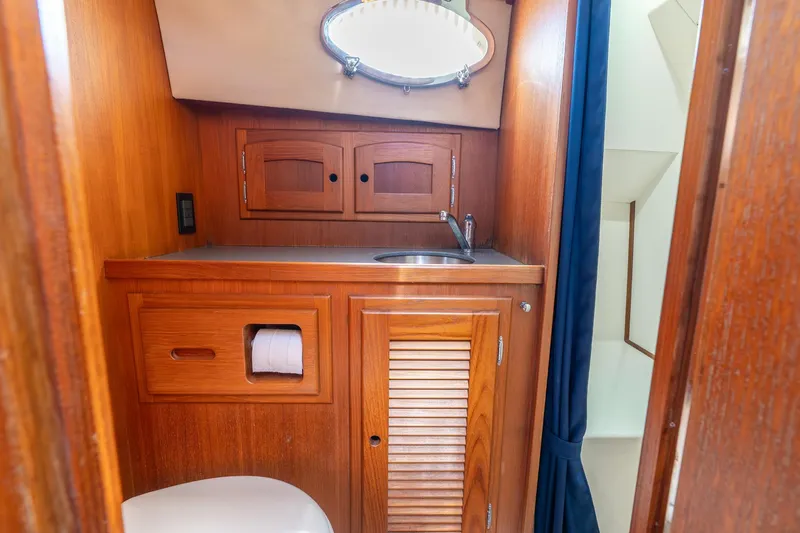 Volatility Yacht Photos Pics Wooden boat bathroom interior with sink, cabinets, and toilet in 2003 San Juan SJ 38.