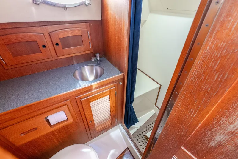 Volatility Yacht Photos Pics 2003 San Juan SJ 38 yacht bathroom with wooden cabinetry and stainless steel sink.