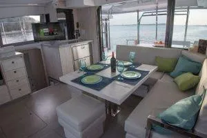 Isola Yacht Photos Pics Luxurious interior of 2018 Leopard 40 catamaran with dining area and ocean view.