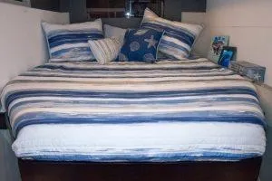 Isola Yacht Photos Pics Cozy bed with blue striped bedding in a 2018 Leopard 40 yacht cabin.