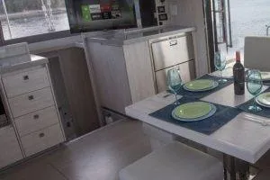 Isola Yacht Photos Pics Modern interior of 2018 Leopard 40 catamaran with dining setup and kitchen area.