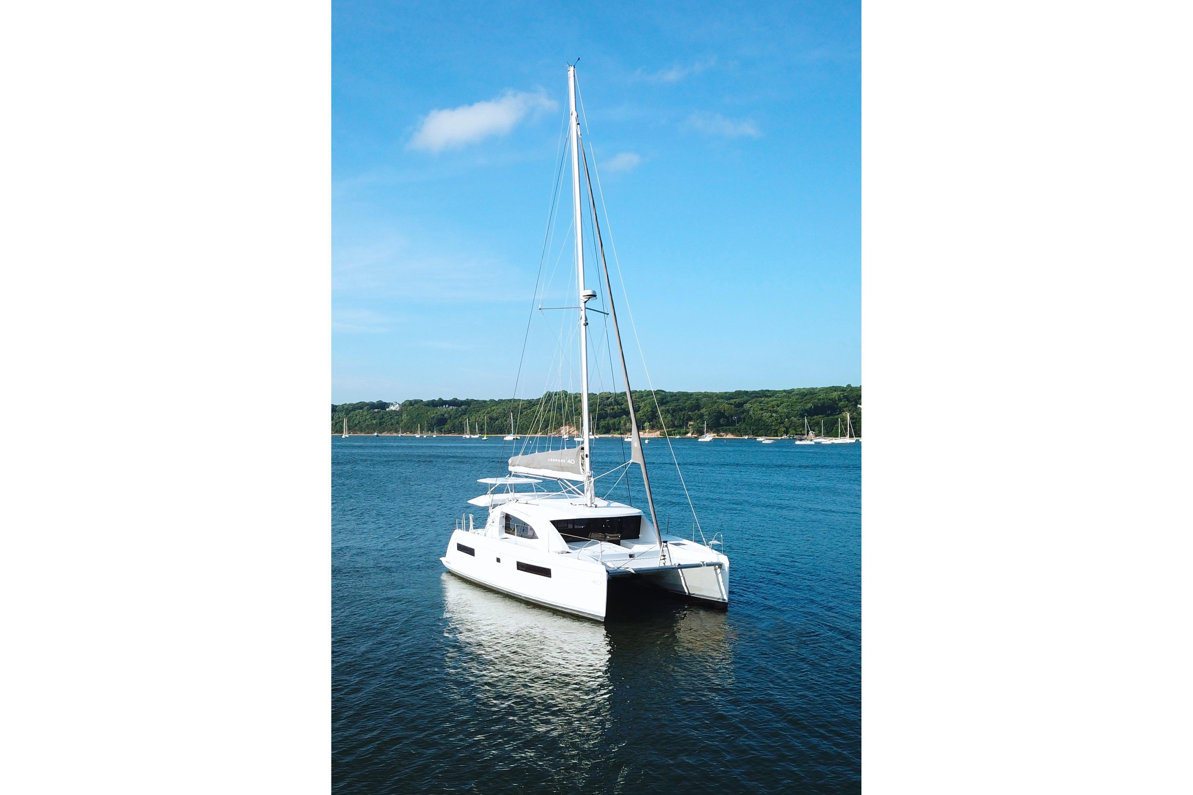 2018 Leopard 40 catamaran sailing on calm blue waters under clear sky.