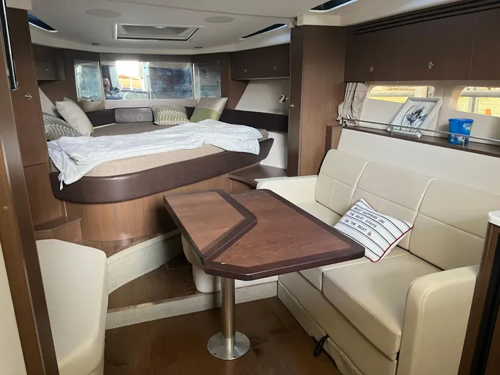 Lady Faby Yacht Photos Pics 2019 Sea Ray Sundancer 350 interior with bed, seating area, and wooden table.