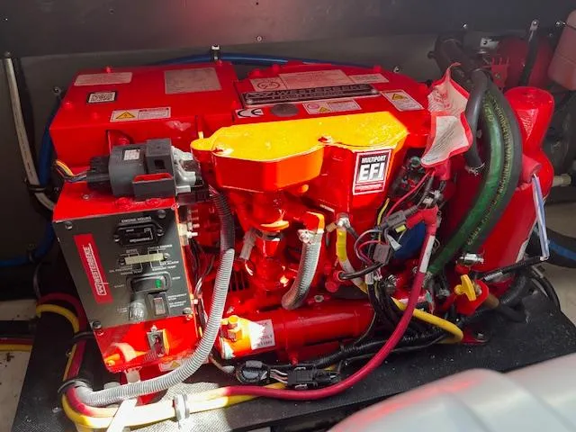  Yacht Photos Pics Engine compartment of a 2022 Monterey 295 Sport Yacht, featuring a bright red motor.