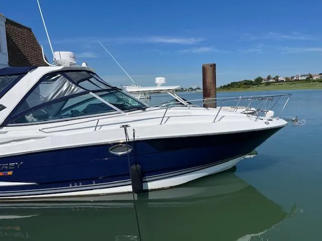  Yacht Photos Pics 2022 Monterey 295 Sport Yacht docked on calm water under clear blue sky.