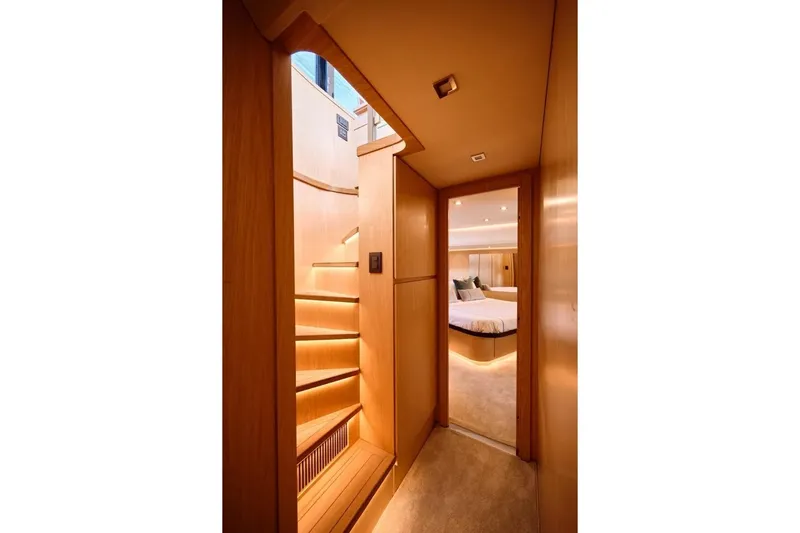 Da Mare Yacht Photos Pics Luxurious interior of 2023 OKEAN 52 yacht, featuring wooden staircase and cozy bedroom.