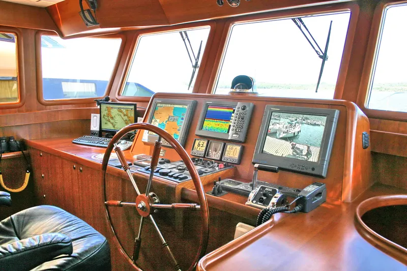  Yacht Photos Pics Pilothouse of 2026 Selene 66 yacht with navigation screens and wooden steering wheel.