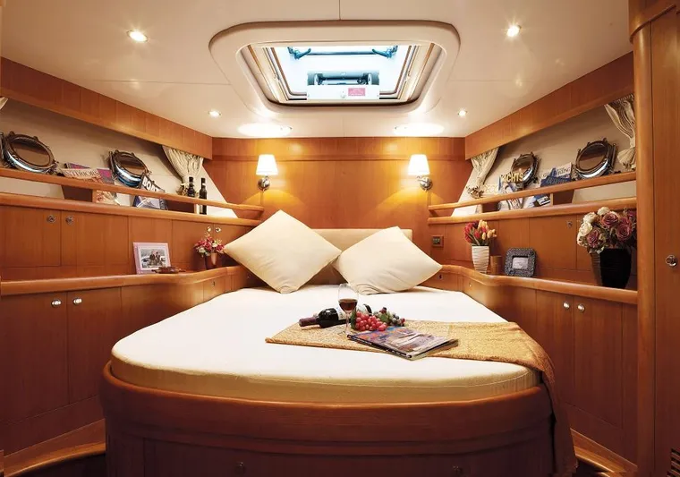  Yacht Photos Pics Luxurious Selene 66 yacht bedroom interior, 2026 model, featuring elegant wood finishes and cozy lighting.