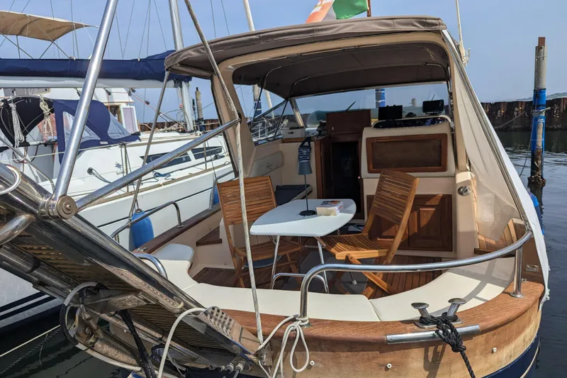  Yacht Photos Pics 2001 Apreamare Smeraldo 9 yacht docked, featuring a cozy seating area with wooden chairs.