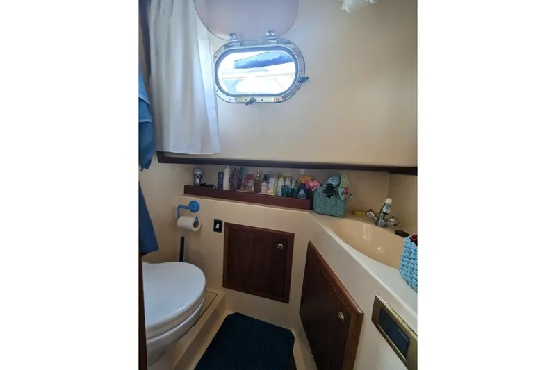  Yacht Photos Pics Bathroom interior of 2001 Apreamare Smeraldo 9 yacht, featuring a porthole and storage.