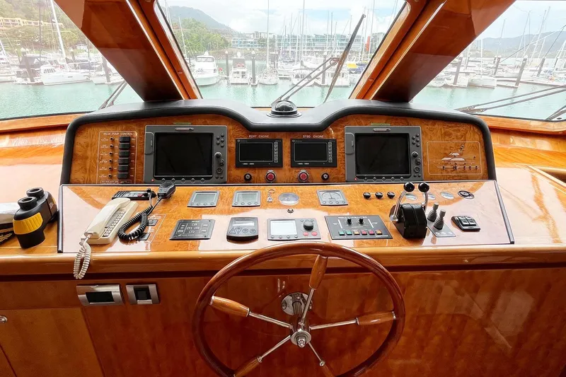 Angelina Yacht Photos Pics Helm of 2005 Monte Fino 73 yacht with navigation instruments and wooden steering wheel.