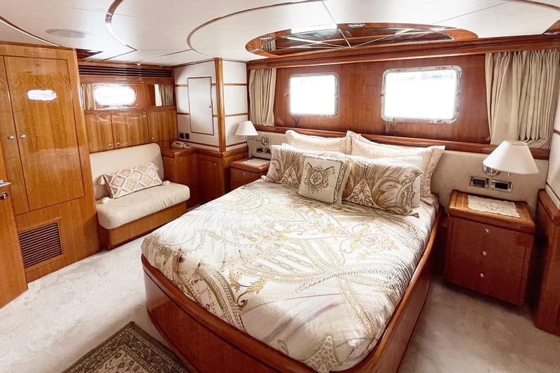 Angelina Yacht Photos Pics Luxurious 2005 Monte Fino 73 yacht bedroom with elegant wood finishes and plush bedding.