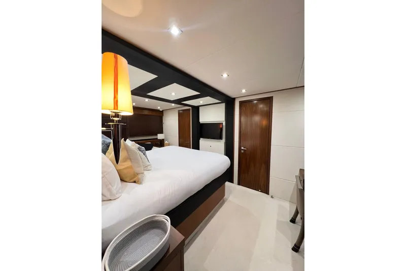 Ohana Yacht Photos Pics Luxurious bedroom interior of 2012 Sunseeker Manhattan 73 yacht, featuring elegant design and cozy ambiance.
