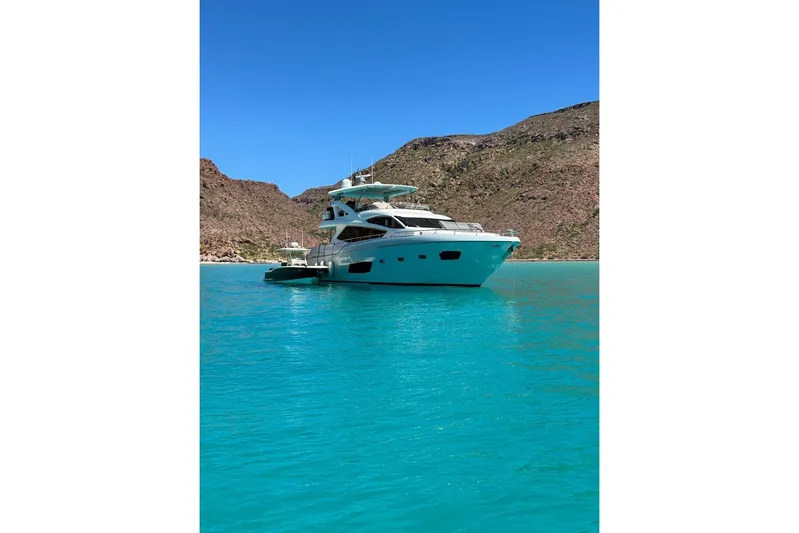 Ohana Yacht Photos Pics Sunseeker Manhattan 73 yacht in turquoise waters, 2012 model, scenic coastal backdrop.