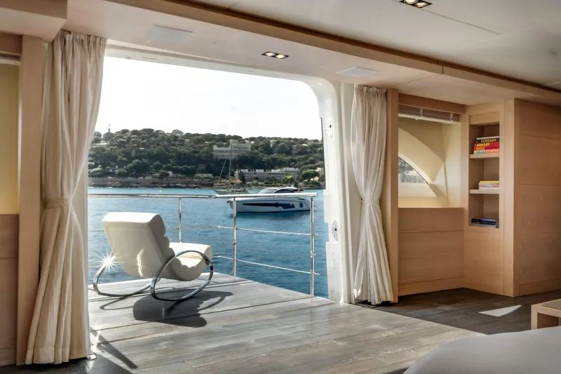 Fast & Furious Yacht Photos Pics Luxurious yacht interior with ocean view, featuring a rocking chair and bookshelf. AB 145, 2016.