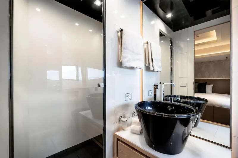 Fast & Furious Yacht Photos Pics Luxurious bathroom with black sink, modern fixtures, and adjacent bedroom in AB 145 yacht, 2016.