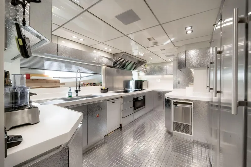 Fast & Furious Yacht Photos Pics Modern yacht kitchen with sleek metallic design, featuring stainless steel appliances and ample counter space.