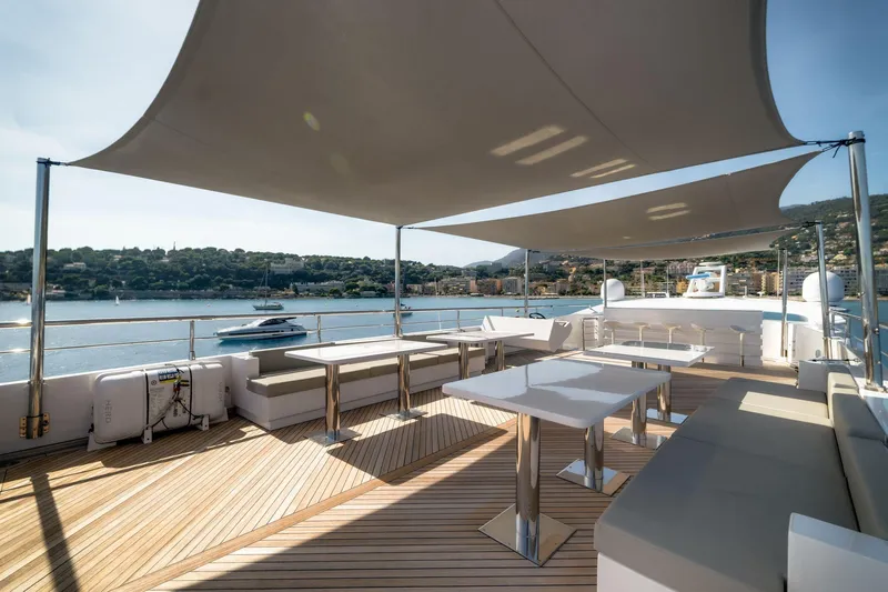 Fast & Furious Yacht Photos Pics Luxurious AB 145 yacht deck with modern seating, shaded canopy, and scenic waterfront view.