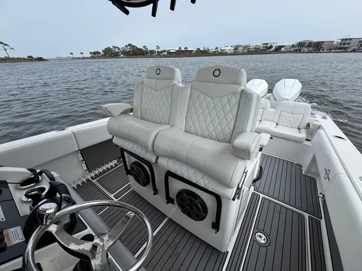  Yacht Photos Pics 2019 Fountain 34 CC boat interior with luxurious seating and steering wheel, overlooking calm waters.