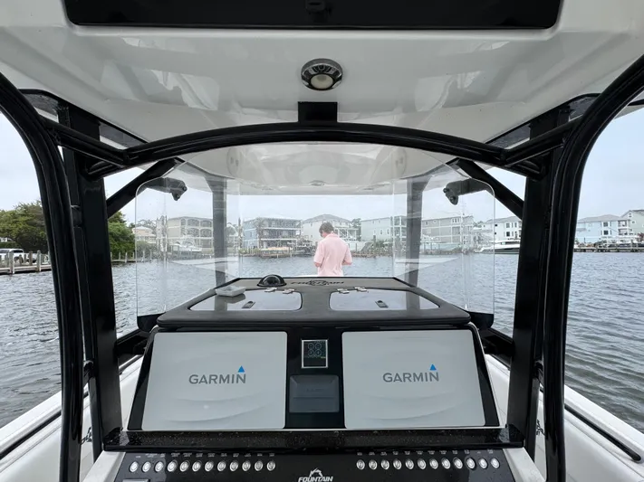  Yacht Photos Pics 2019 Fountain 34 CC boat interior with Garmin navigation, overlooking waterfront homes.