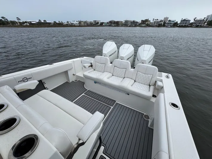  Yacht Photos Pics 2019 Fountain 34 CC boat with triple engines, spacious seating, and sleek design on calm water.