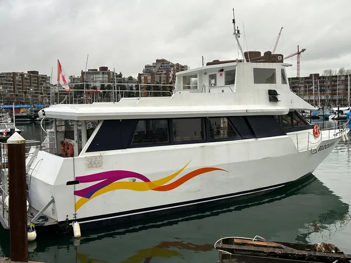 Eloquent Yacht Photos Pics 1990 Palmer Marine 70 Pilothouse yacht docked in marina, featuring colorful side design.