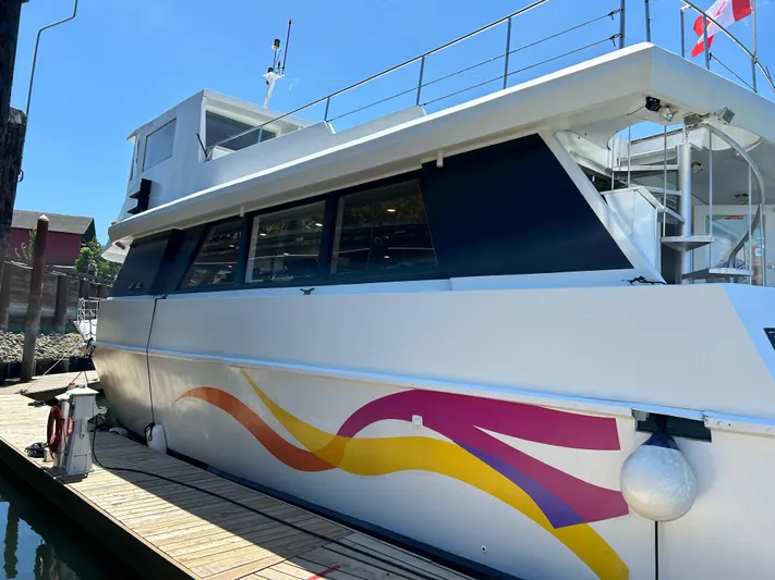 Eloquent Yacht Photos Pics 1990 Palmer Marine 70 Pilothouse yacht docked, featuring colorful wave design on the hull.
