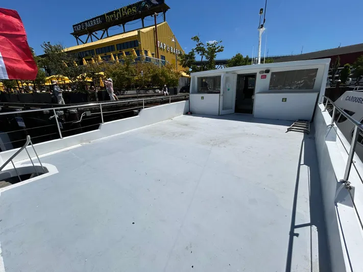 Eloquent Yacht Photos Pics Palmer Marine 70 Pilothouse 1990 boat deck with open space and railing, docked near a restaurant.