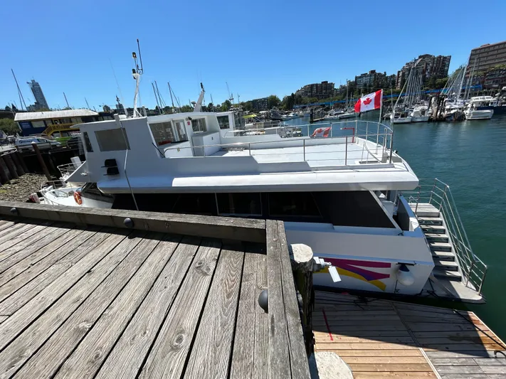Eloquent Yacht Photos Pics 1990 Palmer Marine 70 Pilothouse docked, featuring Canadian flag, in sunny marina setting.